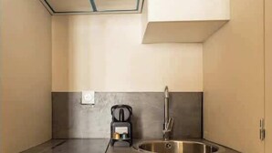 Una cucina compatta con lavastoviglie integrata, lavello in acciaio inossidabile e piano cottura compatto.