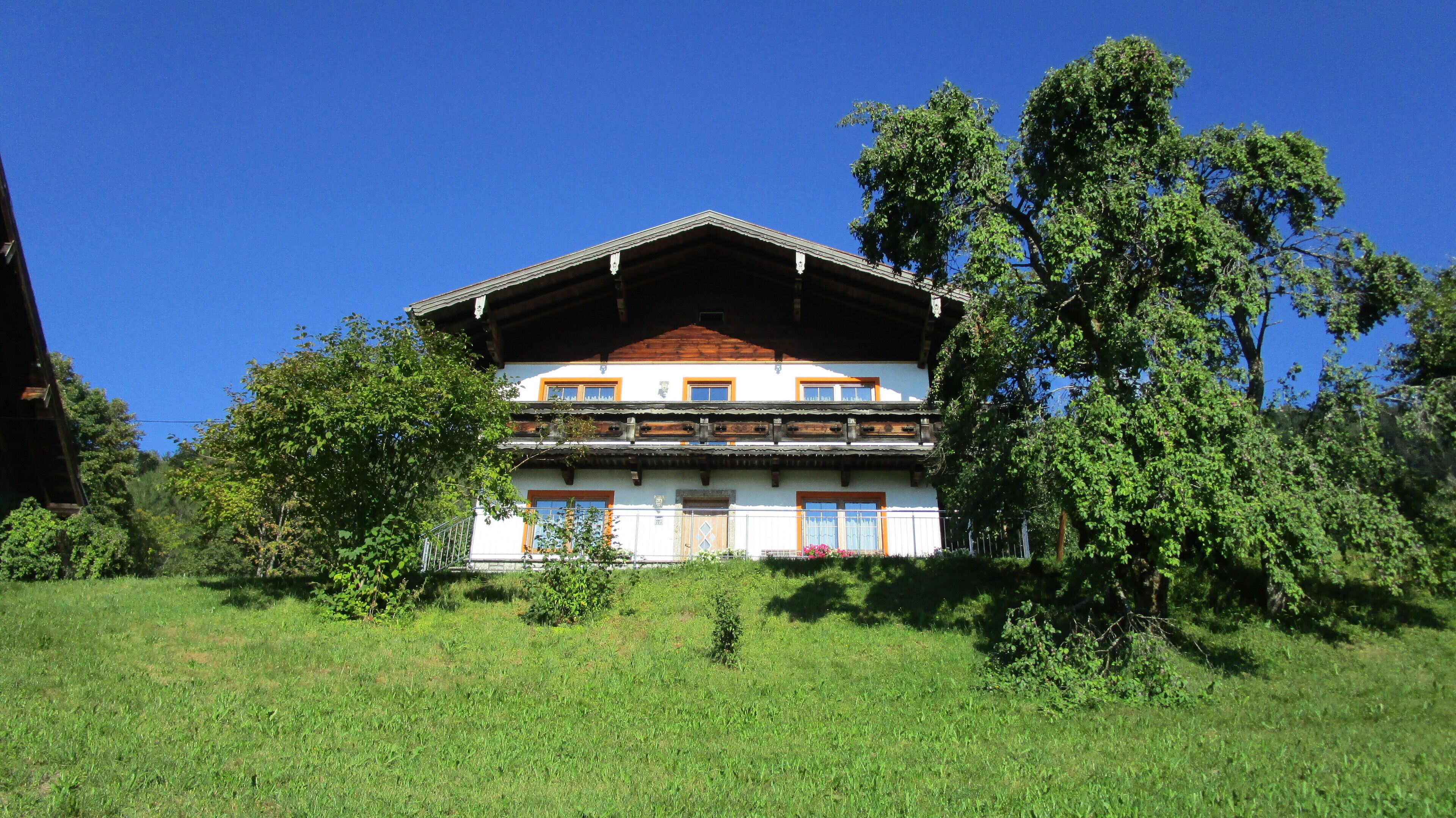A two-story building with a sloped roof, wooden beams, and a balcony.