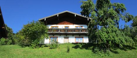 A two-story building with a sloped roof, wooden beams, and a balcony.