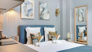 A hotel room with a bed, bedside table, lamp, and artwork on the wall. - Studio climatisé confort & charme – Neuilly (Neuilly-sur-Seine)