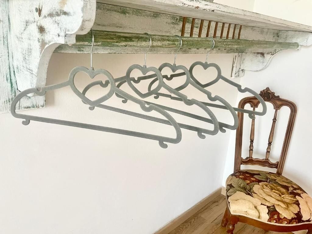 A chair with a floral cushion and a metal coat rack with heart-shaped hangers.