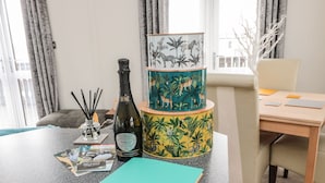 Une pièce comprenant un bureau, une bouteille de vin, un carnet et une lampe décorative sur le thème de la jungle.