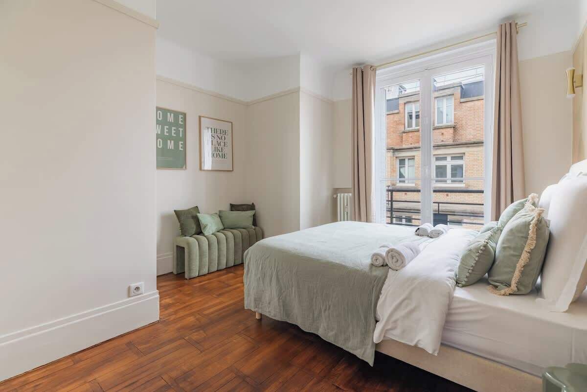 Una camera da letto con un letto, una finestra e un divano verde.