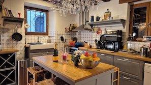 A modern kitchen with a wooden island, stainless steel appliances, and a variety of kitchenware.