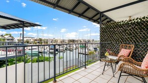 A balcony with wicker chairs, a view of a marina with boats, and a tiled floor. - Zen Dockside Point Marina View - Patio - Parking (Darwin)