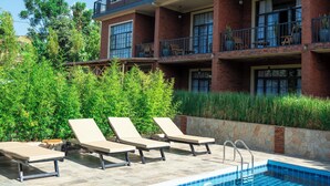 A pool area with lounge chairs and a clear blue pool. - ZONDELA HOUSE (Arusha)