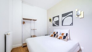 A bedroom with a bed, a wardrobe, and a radiator. - Appartement Cosy aux Portes de Paris (Issy-les-Moulineaux)
