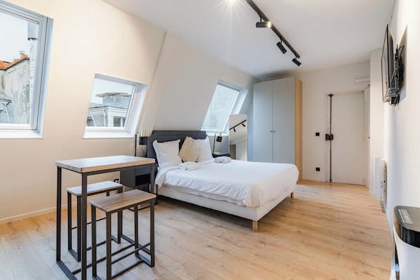 A modern bedroom with a bed, a desk, and two windows. - Cocon pour 2 personnes central - Beaubourg / Notre-Dame (Paris)