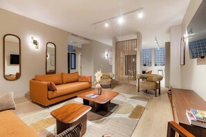 A modern living room with a sofa, coffee table, and chairs. - Grand 4 pièces climatisé avec patio à Paris (Paris)