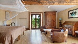 A bedroom with a bed, a wooden cabinet, a desk, and a chair.