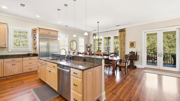 A modern kitchen with wooden cabinets, stainless steel appliances, and a large island. - Knock On Wood 5 Bedroom Home (Georgetown)