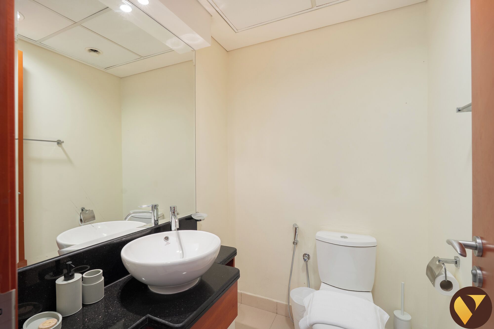 Un baño con lavamanos blanco, inodoro y espejo.