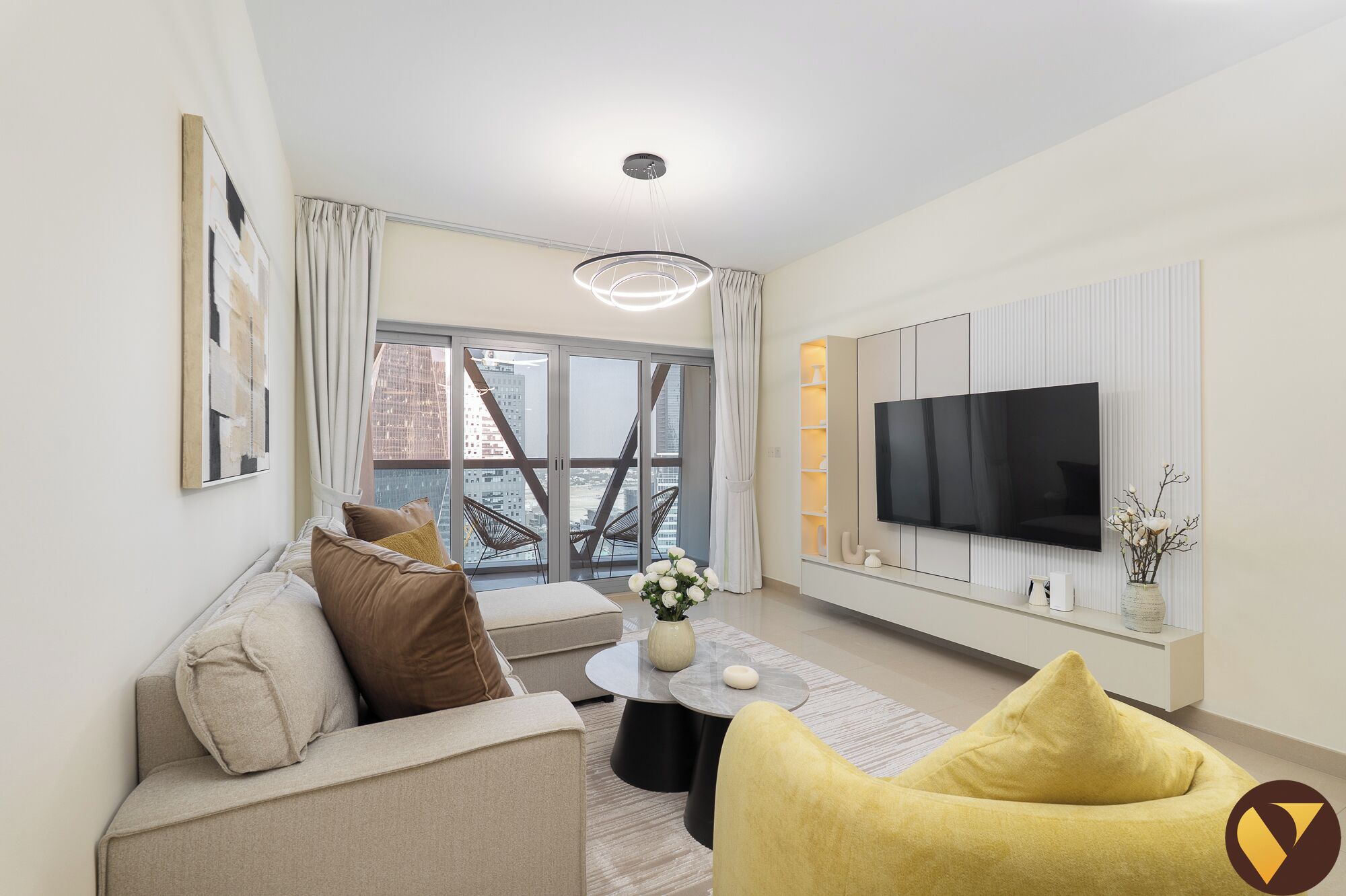 Una sala de estar moderna con sofá, sillón amarillo y televisor en la pared.