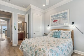 A bedroom with a bed, a painting, and a nightstand. - 1947 S Fletcher 2 Bedroom Townhouse (Fernandina Beach)