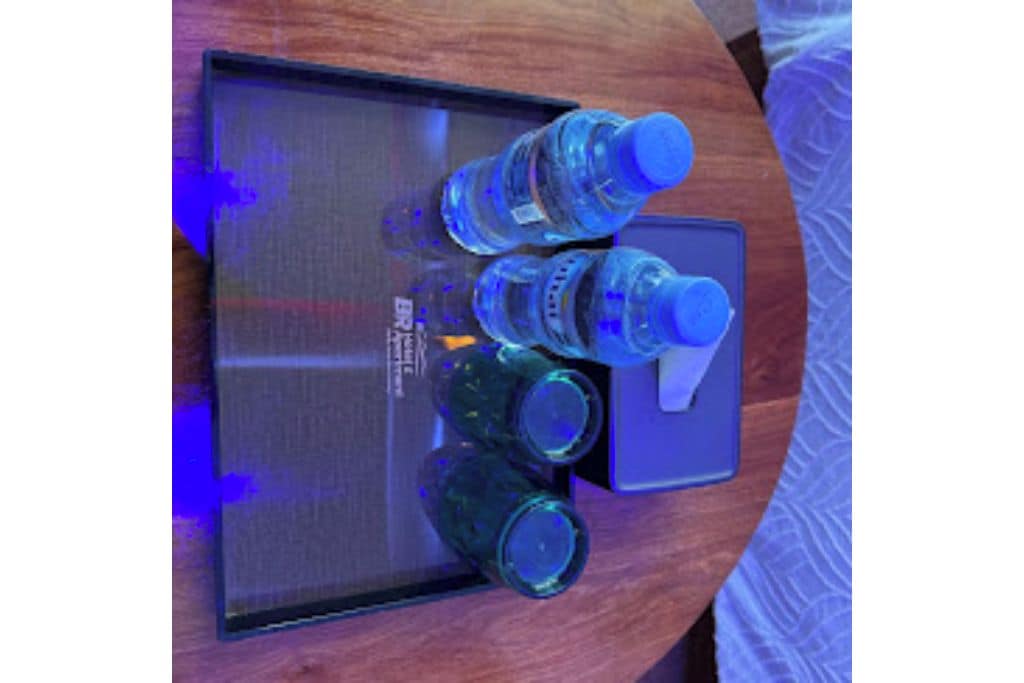 A tray with water bottles and a box on a wooden surface.