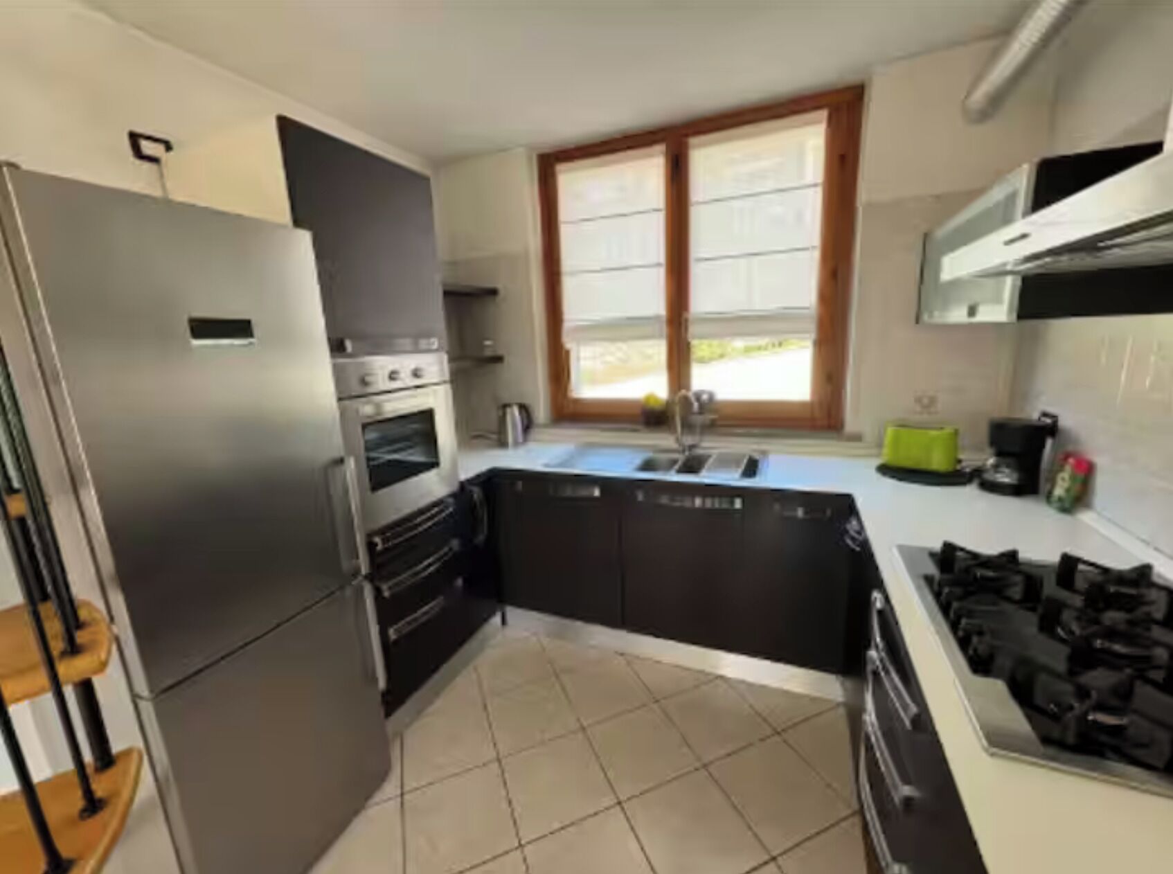 A modern kitchen with a built-in oven, a refrigerator, a sink, and a stove.