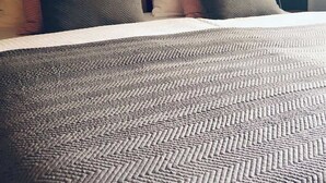 A bed with a patterned blanket and multiple pillows in various colors. - Wanderlust Chiemgau (Bad Endorf)