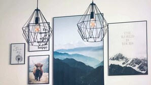 A dining area with a table, two chairs, and three framed pictures on the wall. - Wanderlust Chiemgau (Bad Endorf)