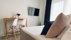 A modern bedroom with a bed, a desk, and a TV. - Wanderlust Trier (Trier)