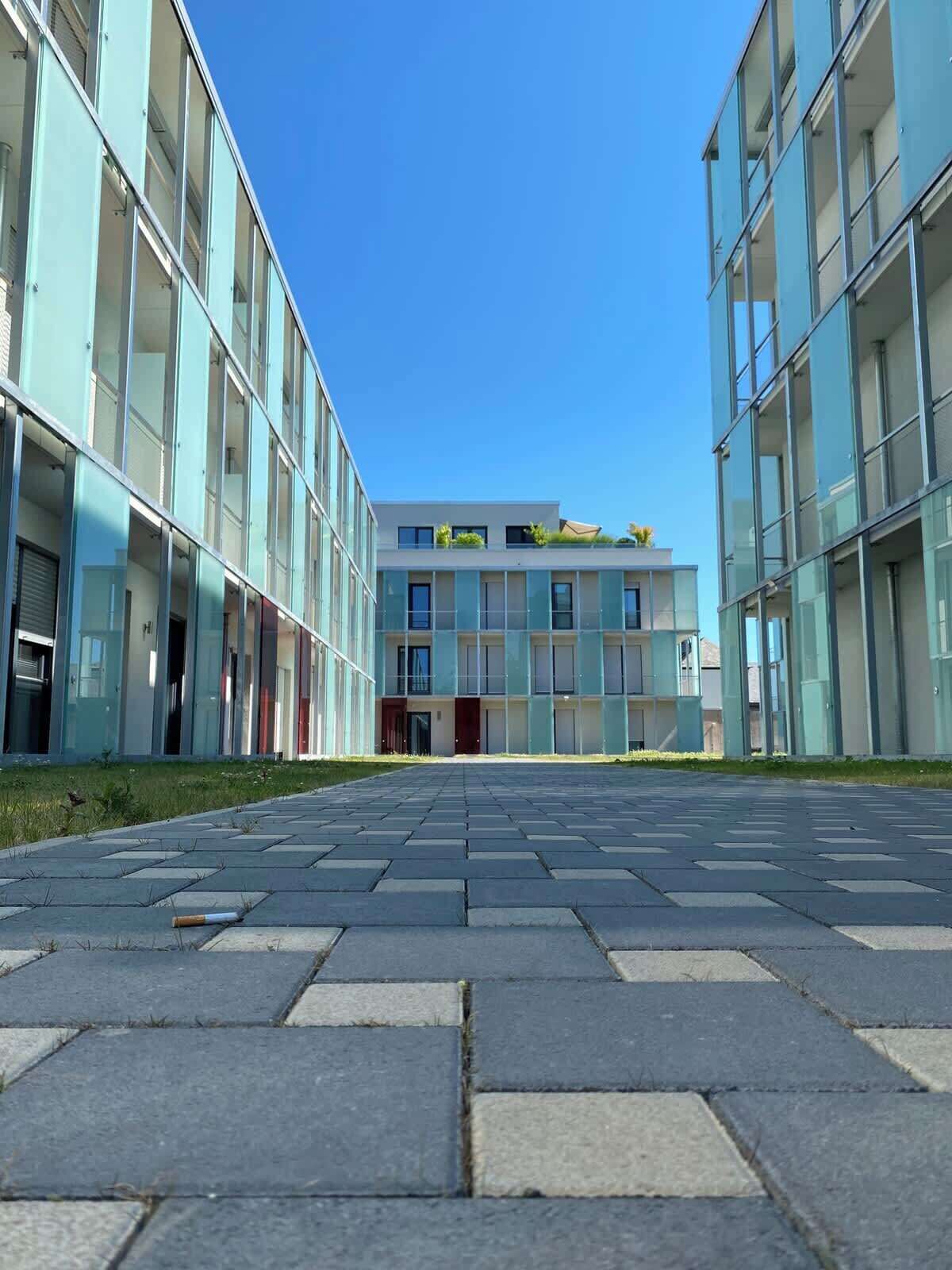 A modern building with a central entrance, large windows, and a flat roof.