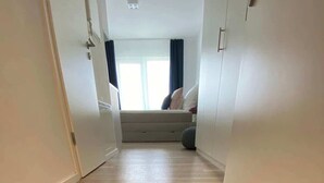 A hallway with a welcome mat and a bed in the background. - Wanderlust Trier (Trier)