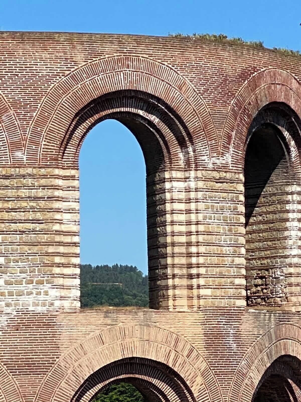 Ein großes, aus Backsteinen errichtetes Gebäude mit mehreren Bögen.