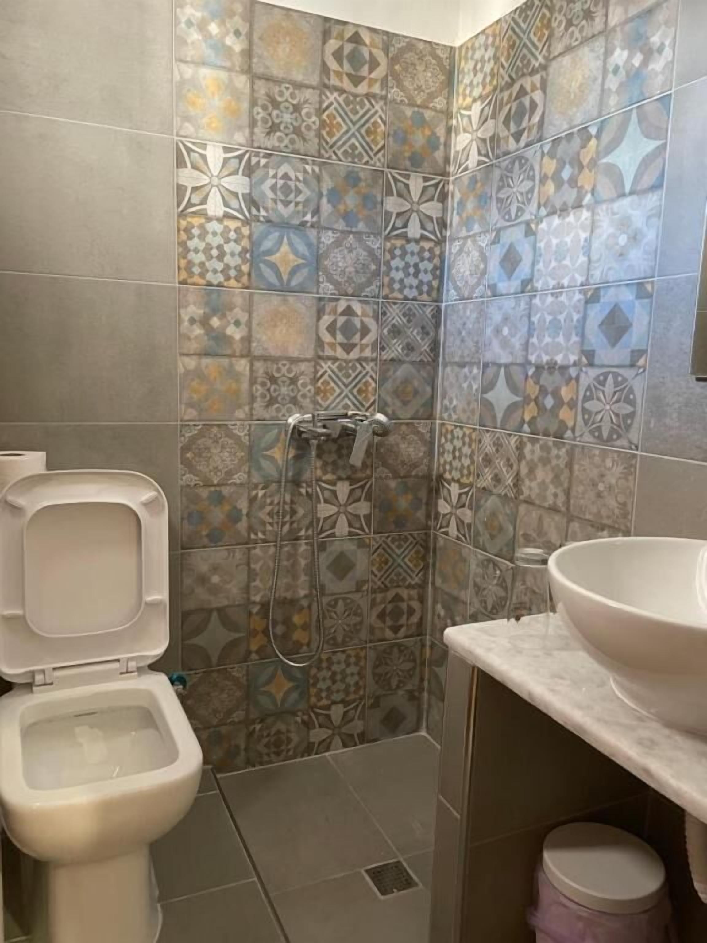 Un baño con inodoro, ducha y lavamanos.