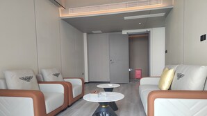 Ett modernt hotellrum med två soffor, ett litet bord och en papperskorg.
