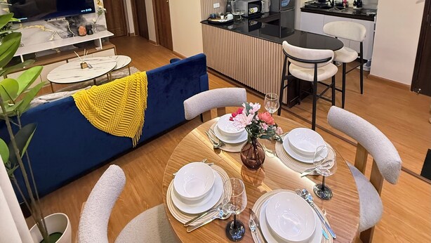 A modern living room with a dining area, a kitchen, and a ceiling fan. - A.Venue Residences Suites Poblacion Makati (Makati City)