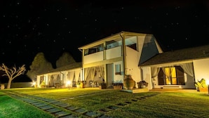 A two-story building with a modern design, featuring a large glass window on the upper floor and a well-lit entrance. - Agriturismo il Montoto - Nature & Relax (Castiglione della Pescaia)
