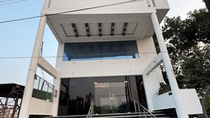 A modern building with a symmetrical facade, large windows, and a central entrance with a staircase. - Hotel Silver Bell (Lucknow)
