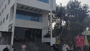 A modern building with a flat roof, large windows, and a staircase leading to the entrance. - Hotel Silver Bell (Lucknow)