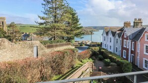 A coastal town with stone walls, a prominent church, and traditional houses with gabled roofs. - 4 The Elms (Salcombe)