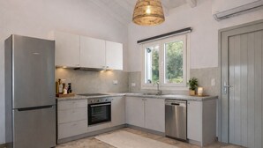 A modern kitchen with stainless steel appliances, a built-in oven, and a dishwasher. - Delux Maisonete 3 Country House with Mountain View, Private Garden and Wi-Fi (Κυρά Χρυσικού)