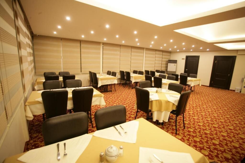 A conference room with multiple tables and chairs, equipped with nameplates and table settings.