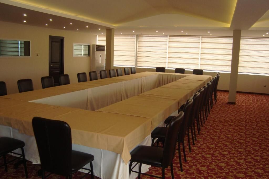 A conference room with a long table, chairs, and large windows with blinds.