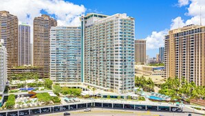 A high-rise hotel with multiple floors, a rooftop pool, and a covered walkway. - Ilikai Hotel Condo with Ocean, Lagoon & Fireworks Views (Honolulu)