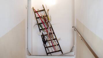 Un escalier avec une échelle en bois appuyée contre le mur.