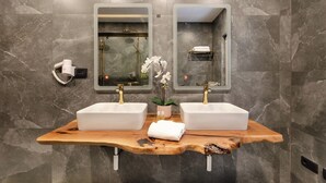A bathroom with two sinks, a wooden vanity, marble walls, and a shower area. - Superior 1-bedroom S2 (Rovinj)