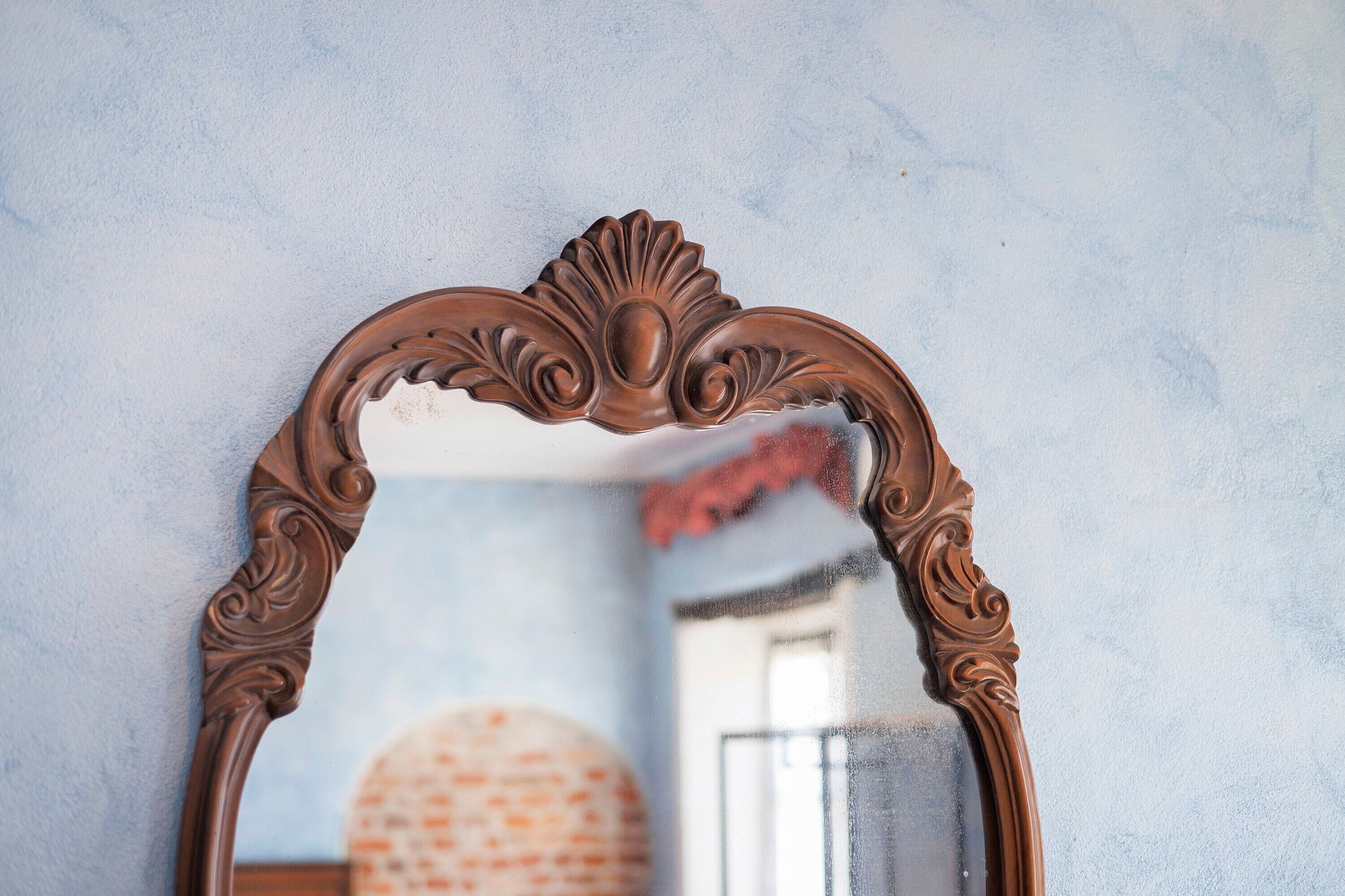 Uno specchio con una cornice decorata.