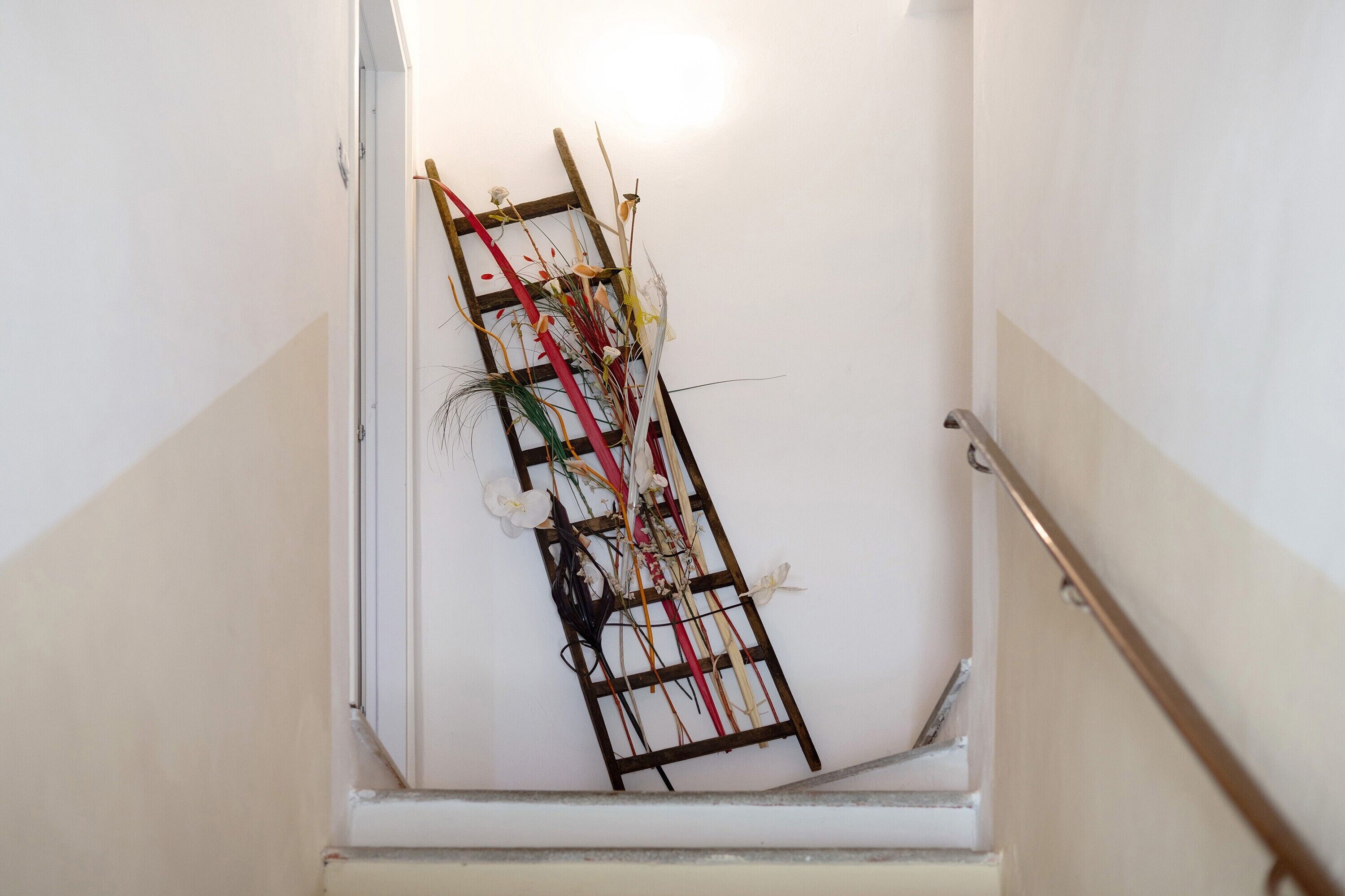 A staircase with a wooden ladder leaning against the wall.
