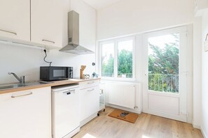 A compact kitchen with a microwave, stove, and sink.