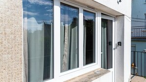 Ein Gebäude mit großen Fenstern, einem Balkon und einer Kachelwand.