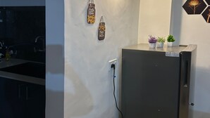 A kitchen with a refrigerator, a wall-mounted light, and a sign with the phrase "Taste is Love". - Experience Comfort, Space, and Privacy at Stay Royal Landran 3 BHK (Mohali)