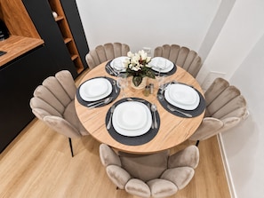A round dining table with four chairs, each with a unique design. - Apartment Perla (Vir)