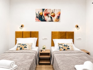A double room with two beds, each with a headboard, a bedside table, and a wall-mounted light fixture. - Apartment Perla (Vir)