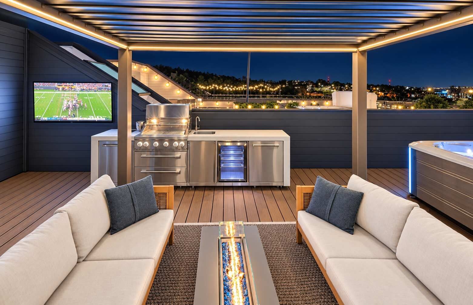 An outdoor patio with a grill, seating area, and a hot tub.