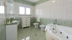 A bathroom with a bathtub, toilet, and sink.