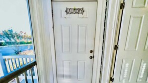 Una porta bianca con un cartello metallico sopra che riporta la scritta 'LAUNDRY'.