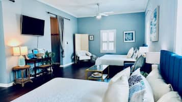 Una habitación con cama, una silla, un escritorio y televisor.